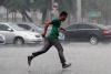 5月24日午后，一场阵雨不期而至，在北京城区东南部一扫而过。入夏后的第一场雨突然降临，让许多路人猝不及防。图为一位行人在雨中迅速跑过路口。