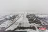 民航华北空管局启动应急预案，工作人员正在努力地给飞机除雪，全力以赴保障旅客出行。图片来源：视觉中国