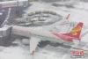 民航华北空管局启动应急预案，工作人员正在努力地给飞机除雪，全力以赴保障旅客出行。图片来源：视觉中国