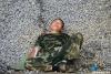 一名战士背靠石堆午睡。 新华网 欧阳小洁摄