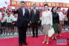 习近平和夫人彭丽媛在机场向欢迎的人群致意。