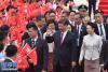习近平和夫人彭丽媛在机场向欢迎的人群致意。