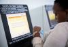 11月10日，在肯尼亚内罗毕蒙内铁路内罗毕站，一名乘客在自助取票机前查看刚刚打印出的车票。