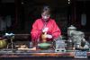 4月3日，长兴县水口乡大唐贡茶院的茶艺师用古法将茶饼捣碎，准备煮茶。新华社记者 徐昱 摄