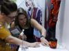8月12日，在美国拉斯维加斯，两名嘉宾在中国鞋类品牌推广活动上观看展品。新华社记者 李颖 摄