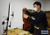 　4月19日，北京华东乐器有限公司工作人员在直播中展示小提琴细节。 新华社记者 任超 摄