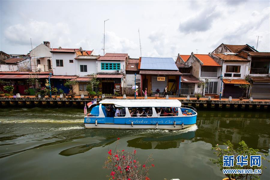 这是2018年6月9日，在马来西亚马六甲，游客乘船游览马六甲河沿岸。 新华社记者 朱炜 摄