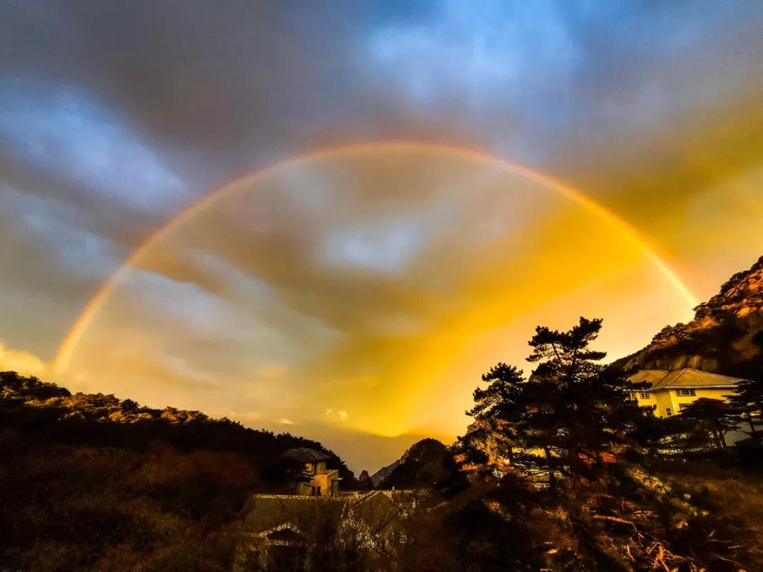 11月17日清晨，在黄山风景区光明顶、玉屏楼等处，面对着东方观赏日出美景，天际形状各异的云彩，在朝阳的渲染下，云霞像着了火似的在山峰上空熊熊燃烧。而更神奇的是，在黄山上空的西北部，只见一道“双彩虹”架在群山之间，宛如一座七彩“银河鹊桥”，五百里黄山如梦如幻。据景区气象部门负责人王新来介绍，日出、降雨、彩虹、火烧云等同现的景象非常少见。今晨黄山风景区出现这样的气象景观主要原因是受西南暖湿气流的影响，日出前黄山景区自西向东开始降雨，初升的太阳光线在空中经过折射形成美丽的彩虹(通讯员 侯晏，光明日报全媒体记者 常河)