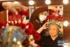 3月16日，戏曲盔头制作维修师朱宝辉（左）在河北省石家庄大剧院后台为演员试戴盔头。新华社发（陈其保 摄）