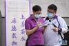 6月7日，在北京市陈经纶中学考点，一位考生（右）在考前与送考老师交流。新华社记者 鞠焕宗 摄