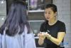 王晓璐（右）在店里向顾客介绍自己设计制作的银花丝首饰（7月18日摄）。
