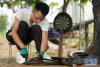 8月10日，曹胜歌在切割废旧轮胎。 新华社记者 牟宇 摄 