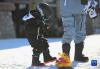 小朋友在长白山国际度假区滑雪场滑雪前穿上雪板（11月19日摄）。新华社记者 颜麟蕴 摄