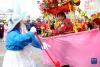 2月13日，民间艺人在江苏省连云港市连云区街头表演“划旱船”。新华社发（王春 摄）