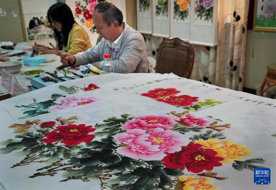 4月16日，画师在河南省洛阳市国家牡丹园内进行牡丹画创作。 新华社记者 李安 摄