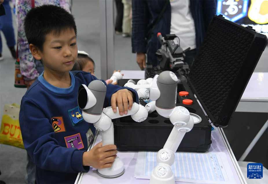 4月27日，小朋友在北京科幻嘉年华现场组装一款机器人。新华社记者 任超 摄