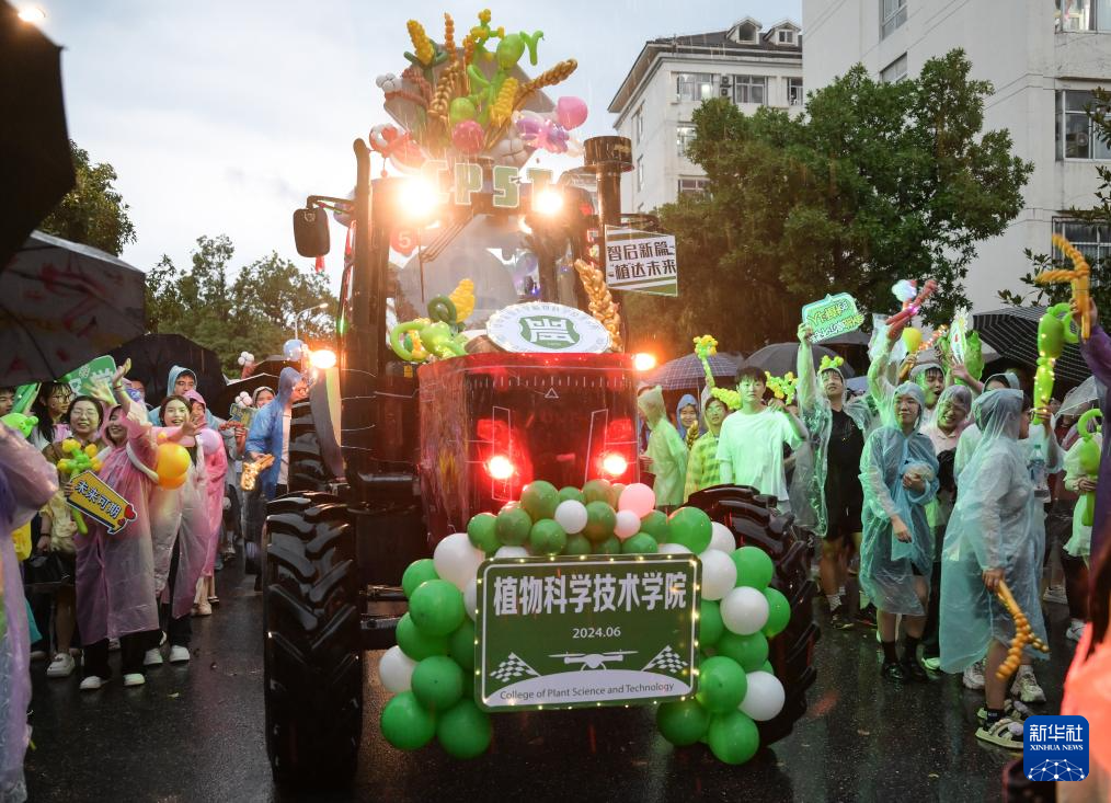 6月21日，农机花车队伍在华中农业大学校园里冒雨巡游。新华社记者 程敏 摄