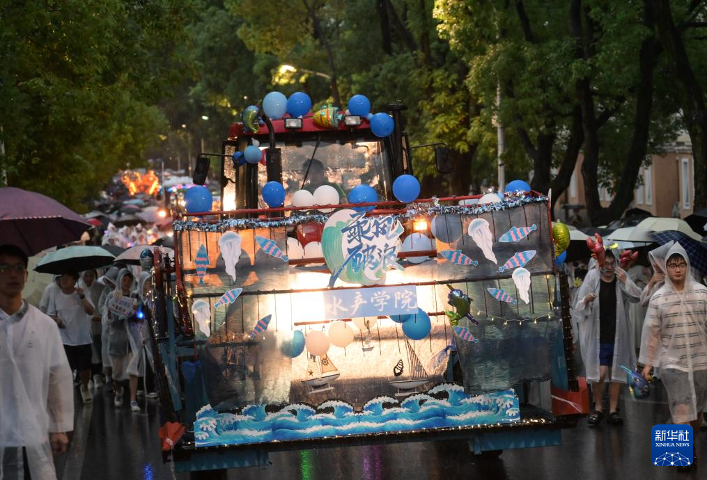 6月21日，农机花车队伍在华中农业大学校园里冒雨巡游。新华社记者 程敏 摄