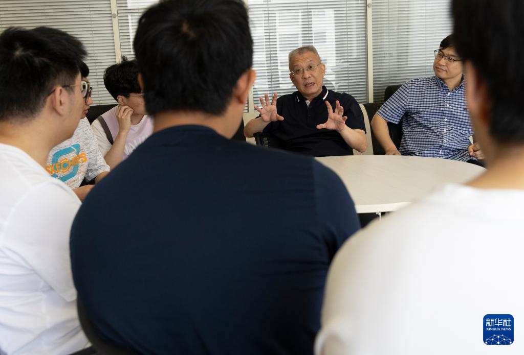 6月19日，在中国科学院物理研究所，方忠（右二）、翁红明和学生们在一起交流。新华社记者 金立旺 摄