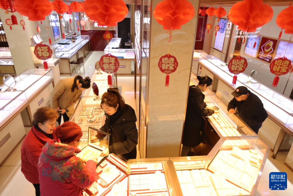 2月11日，顾客在浙江省湖州市德清县乾元镇一家金店挑选黄金首饰。新华社发（倪立芳摄）