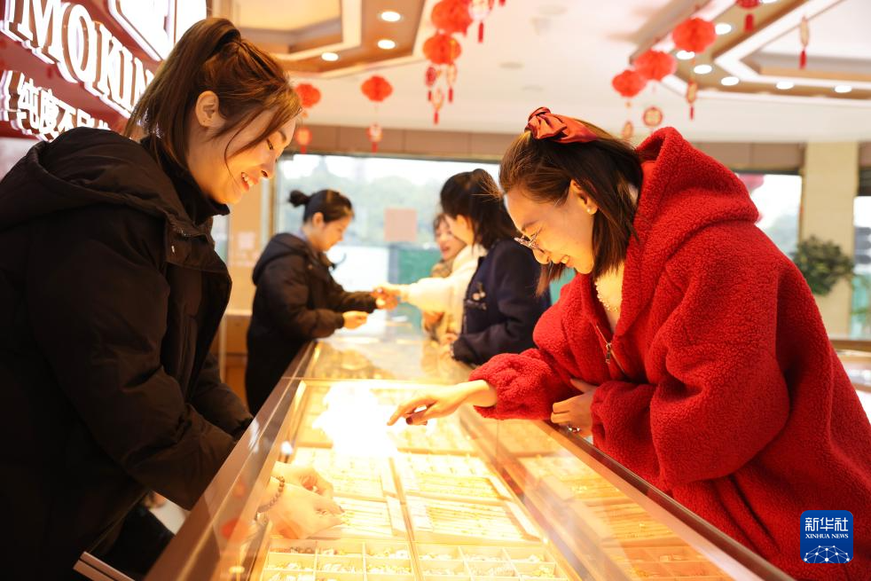 2月11日，顾客在浙江省湖州市德清县乾元镇一家金店挑选黄金首饰。新华社发（倪立芳摄）