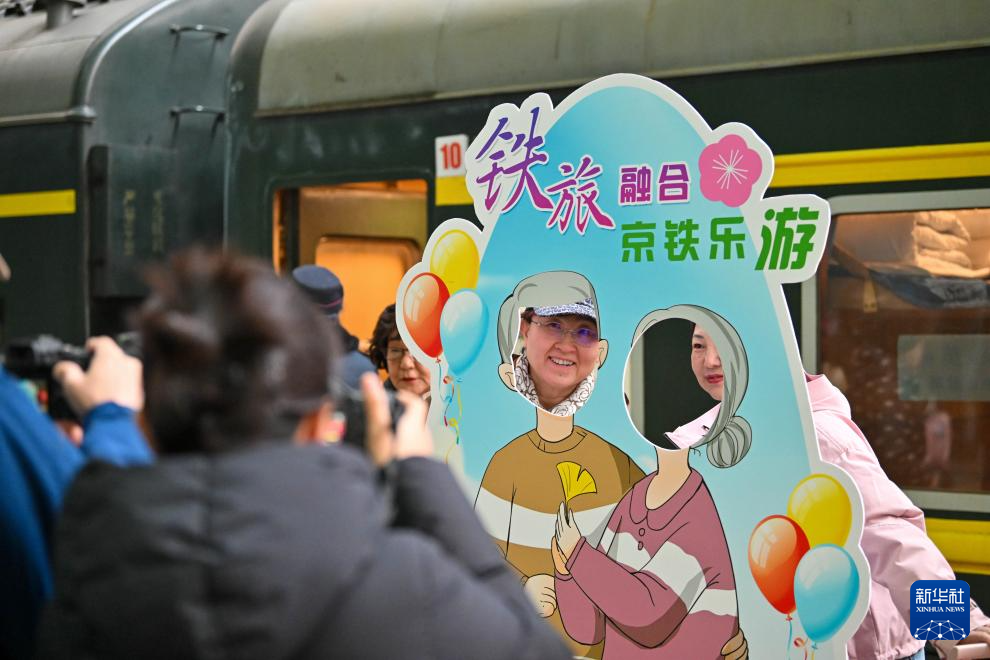3月15日，在天津站站台，银发族游客在“京铁乐游”号银发旅游列车发车前拍照留念。新华社记者 孙凡越 摄