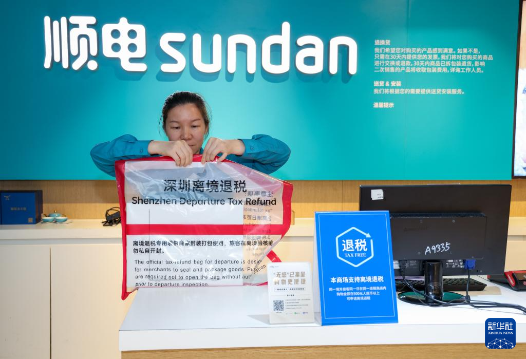 4月30日，在深圳万象城顺电门店，工作人员使用标准密封袋为顾客选购的电子产品进行离境退税“一单一包”打包。新华社记者 毛思倩 摄